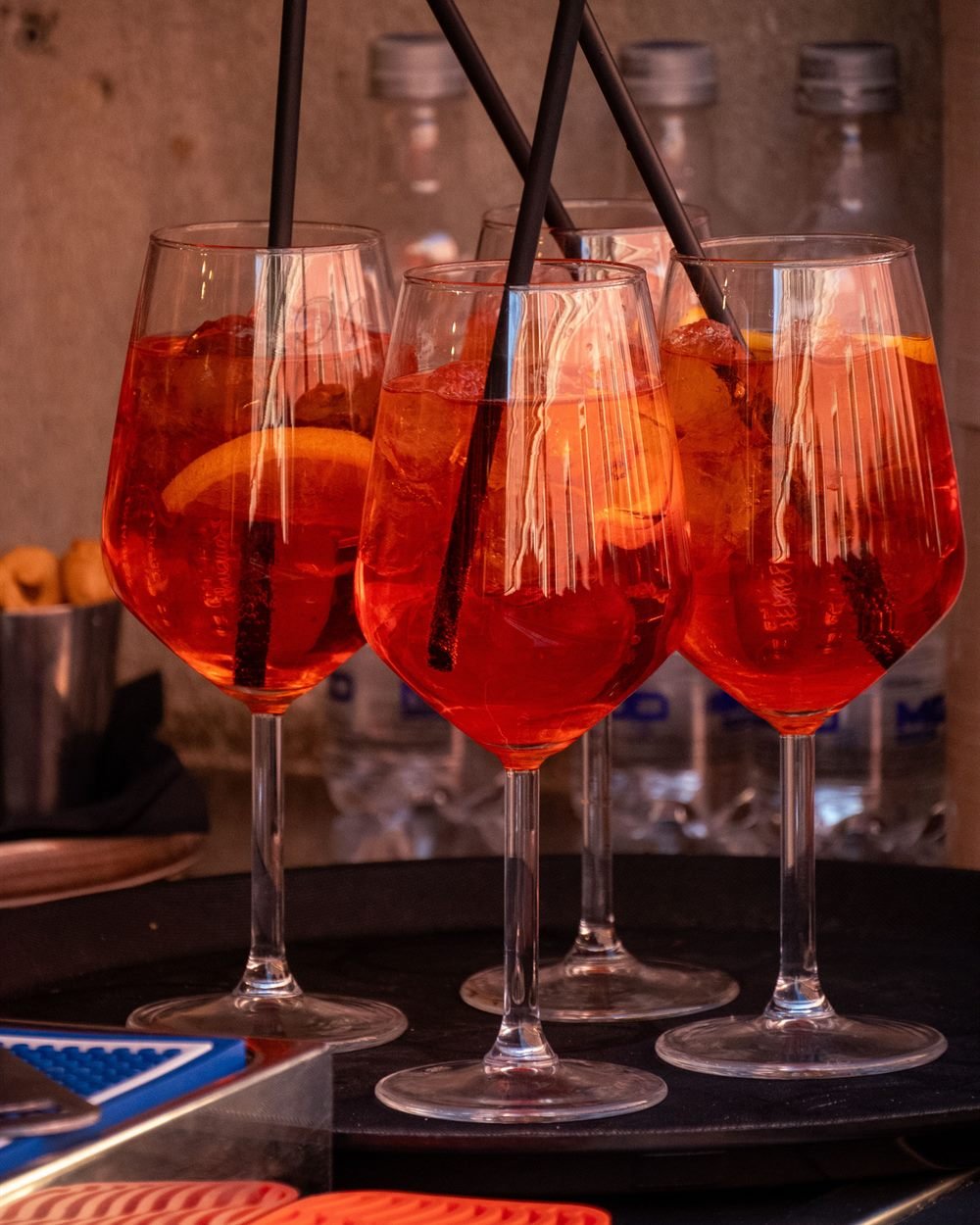 Copas de Aperol Spritz con rodaja de naranja sobre charola